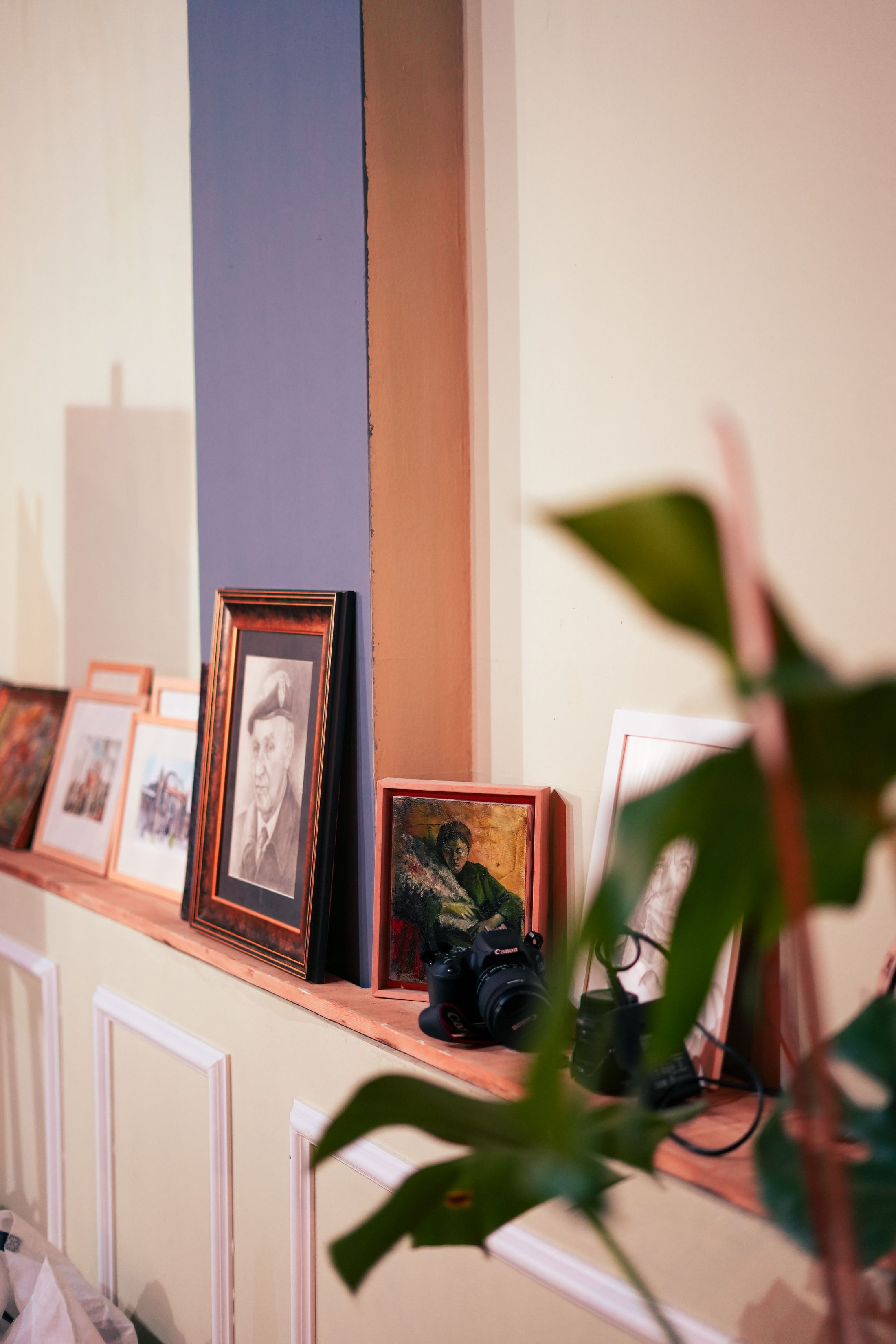 Photographs and framed artwork on a shelf in a real home